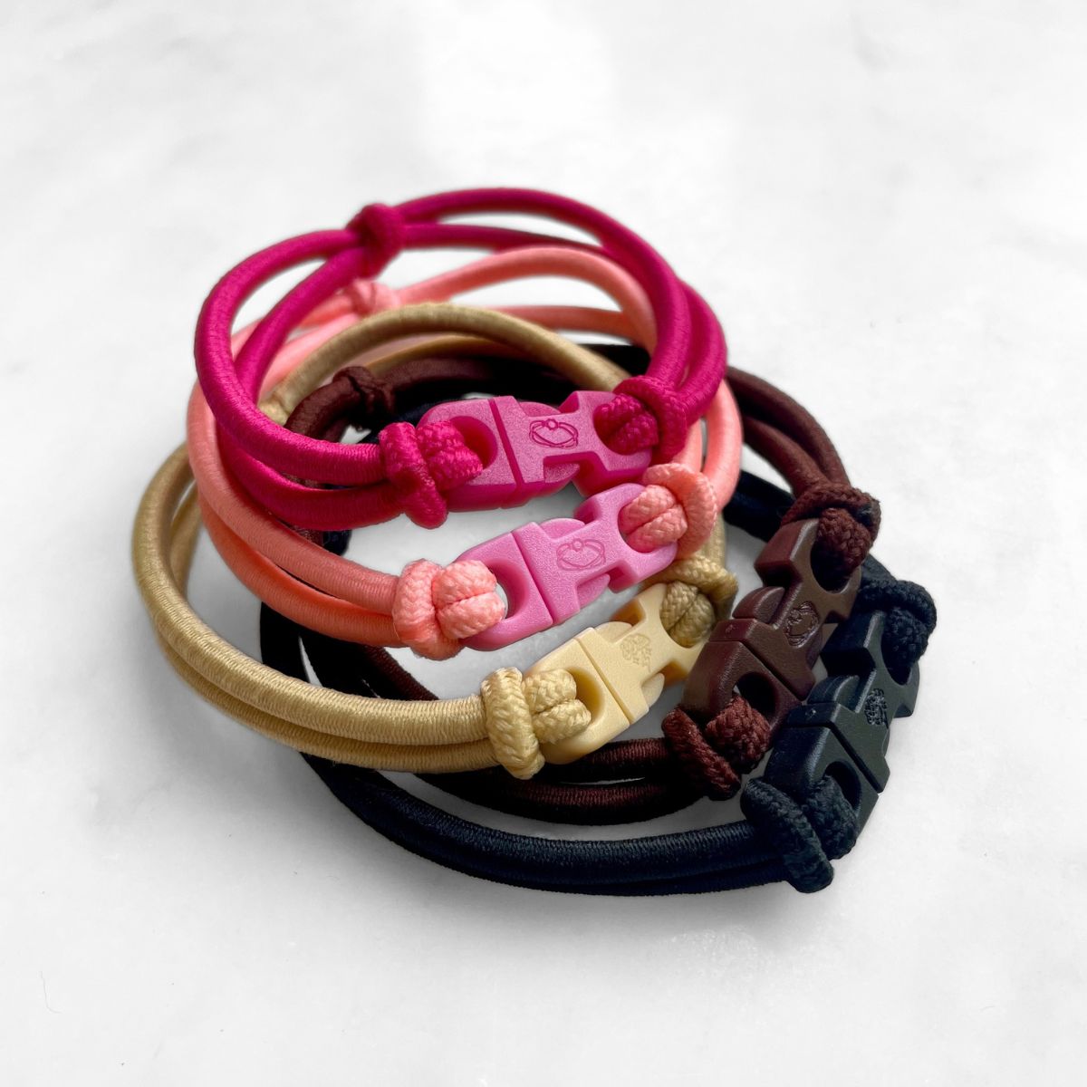 Variety stack of Buckle Hair Ties in all five colors with their buckles facing out