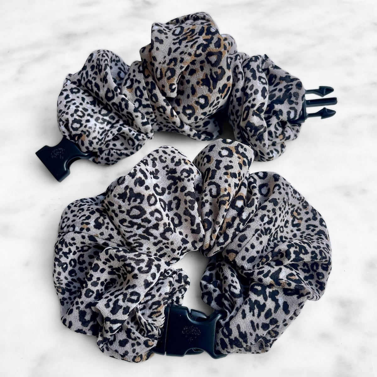 Sandy Leopard Jumbo Buckle Scrunchie: two leopard print chiffon Buckle Scrunchies, one open showing the navy buckle prongs