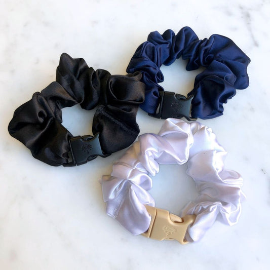Three neutral Buckle Scrunchies in black, beige, and navy recycled satin