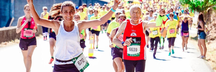 Running accessories for women: Runners with race bibs smiling during a road race