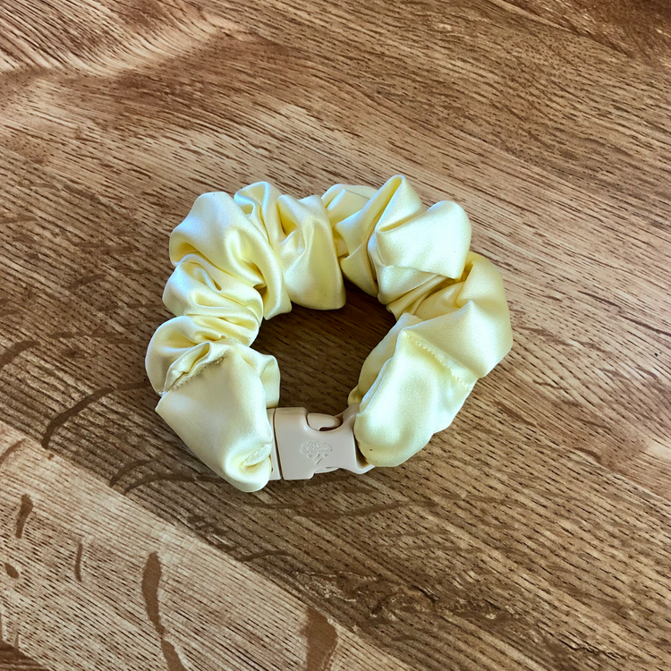Bridal shower party favors: Ivory satin Buckle Scrunchie on a wood surface