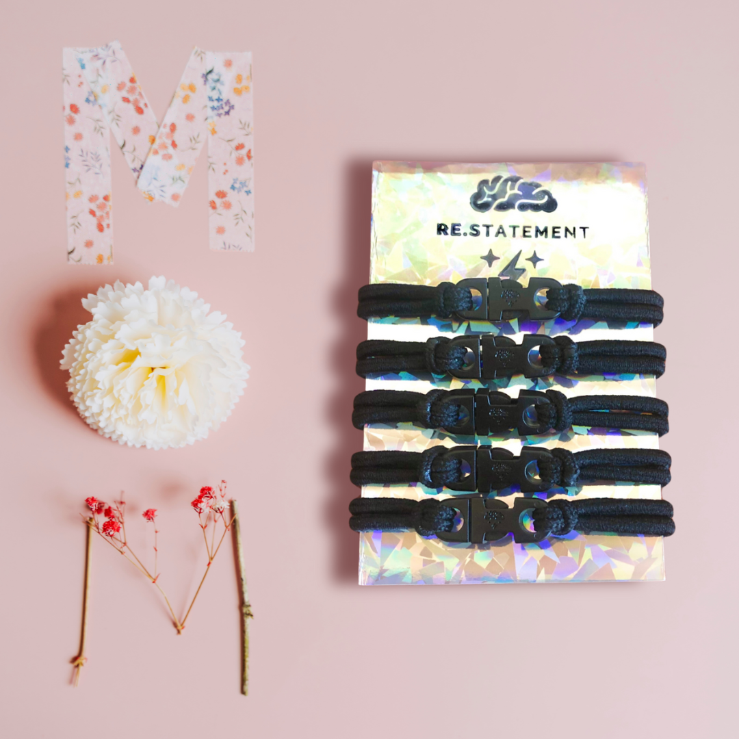 Party favors: Pink flat lay with a card of black Buckle Hair Ties and confetti