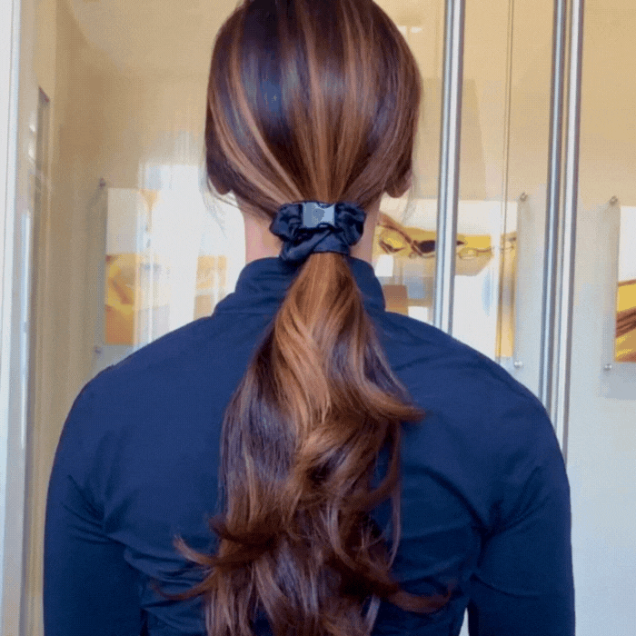 Teal Buckle Scrunchie fastened in a secure half-up hairstyle on long brown wavy hair
