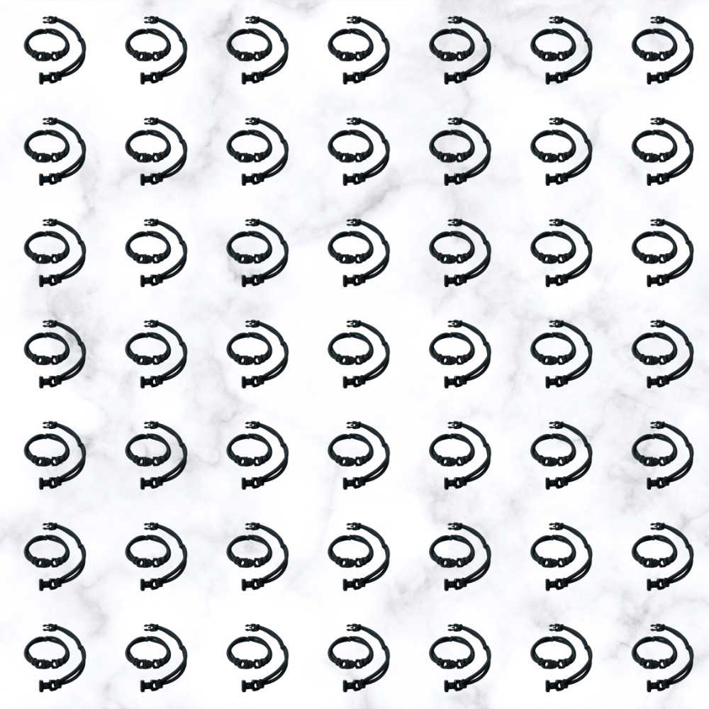 Grid of black Buckle Hair Tie elastics on marble, 100-pack bulk team pack for cheer, gymnastics, volleyball, track, and running