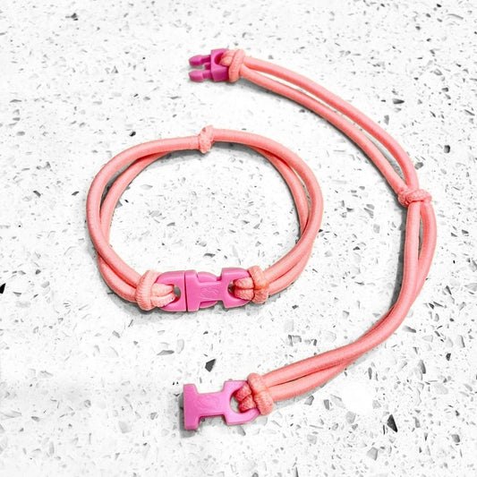 Baby Pink Buckle Hair Tie elastic clasped in a loop beside an open one showing the pink quick release buckle
