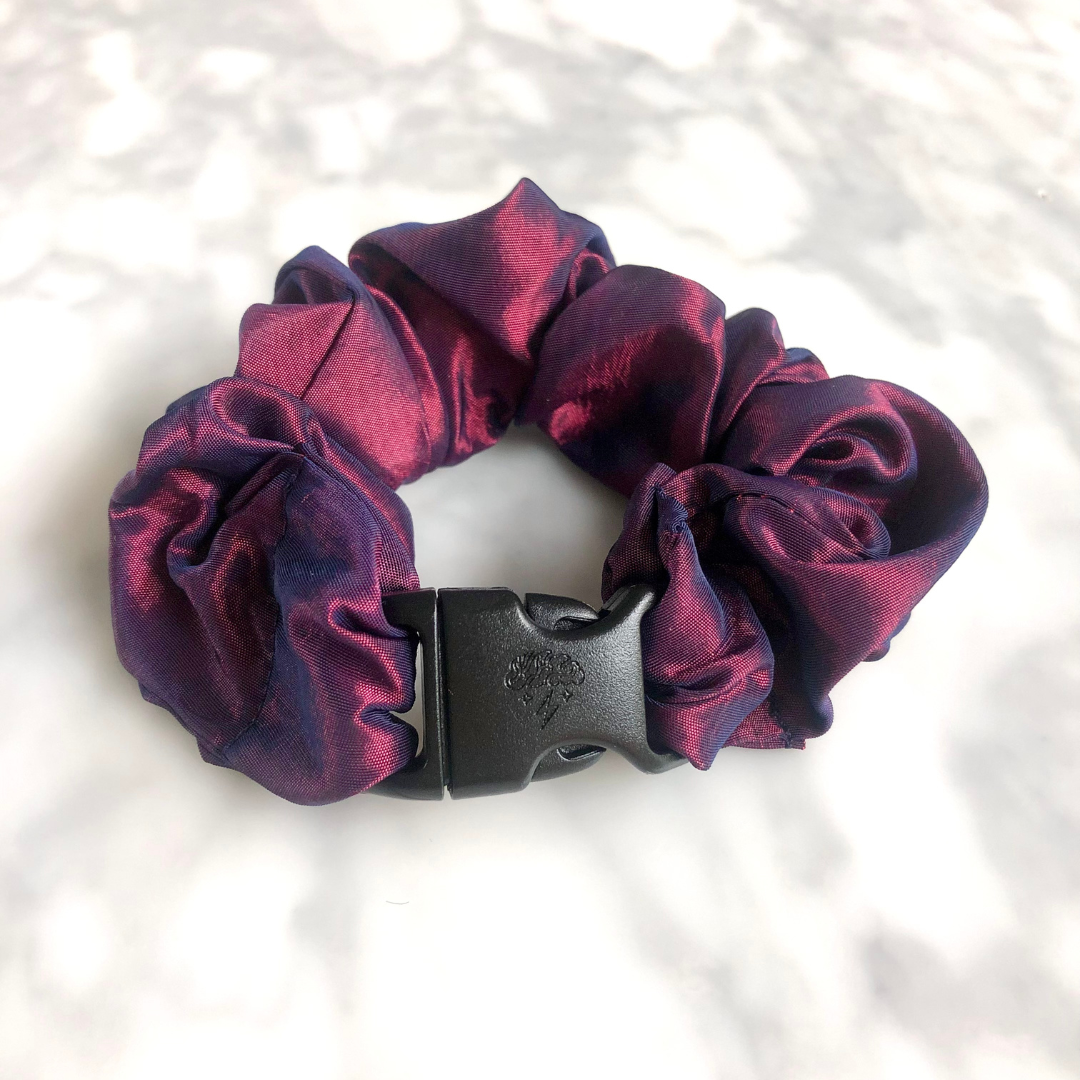 Metallic red and blue fabric detail on the Astral Fire Buckle Scrunchie