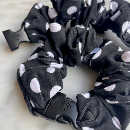 Overhead detail of a black and white polka dot Buckle Scrunchie and its black buckle