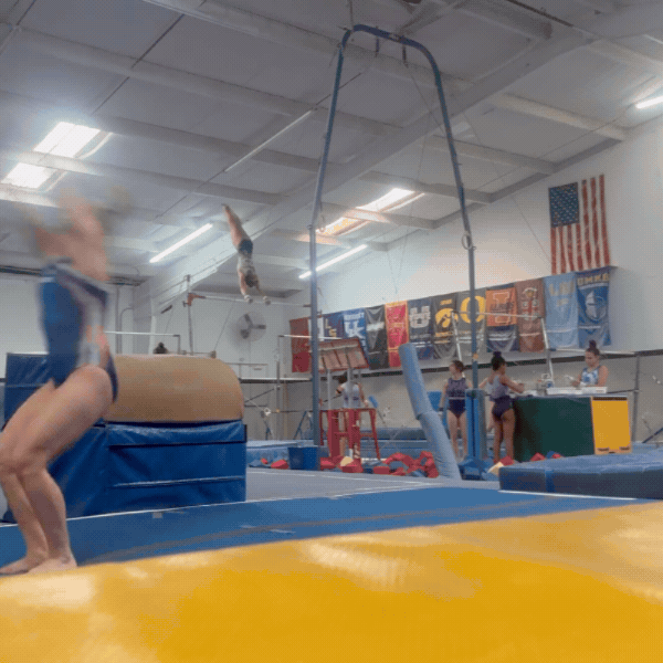 Gymnast in a gym tying her hair back before a routine