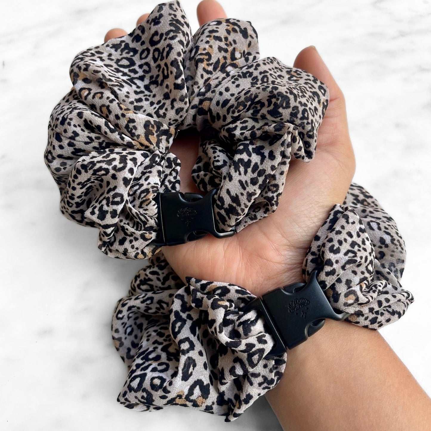 Leopard print Buckle Scrunchie worn on the wrist like a bracelet with a second in hand