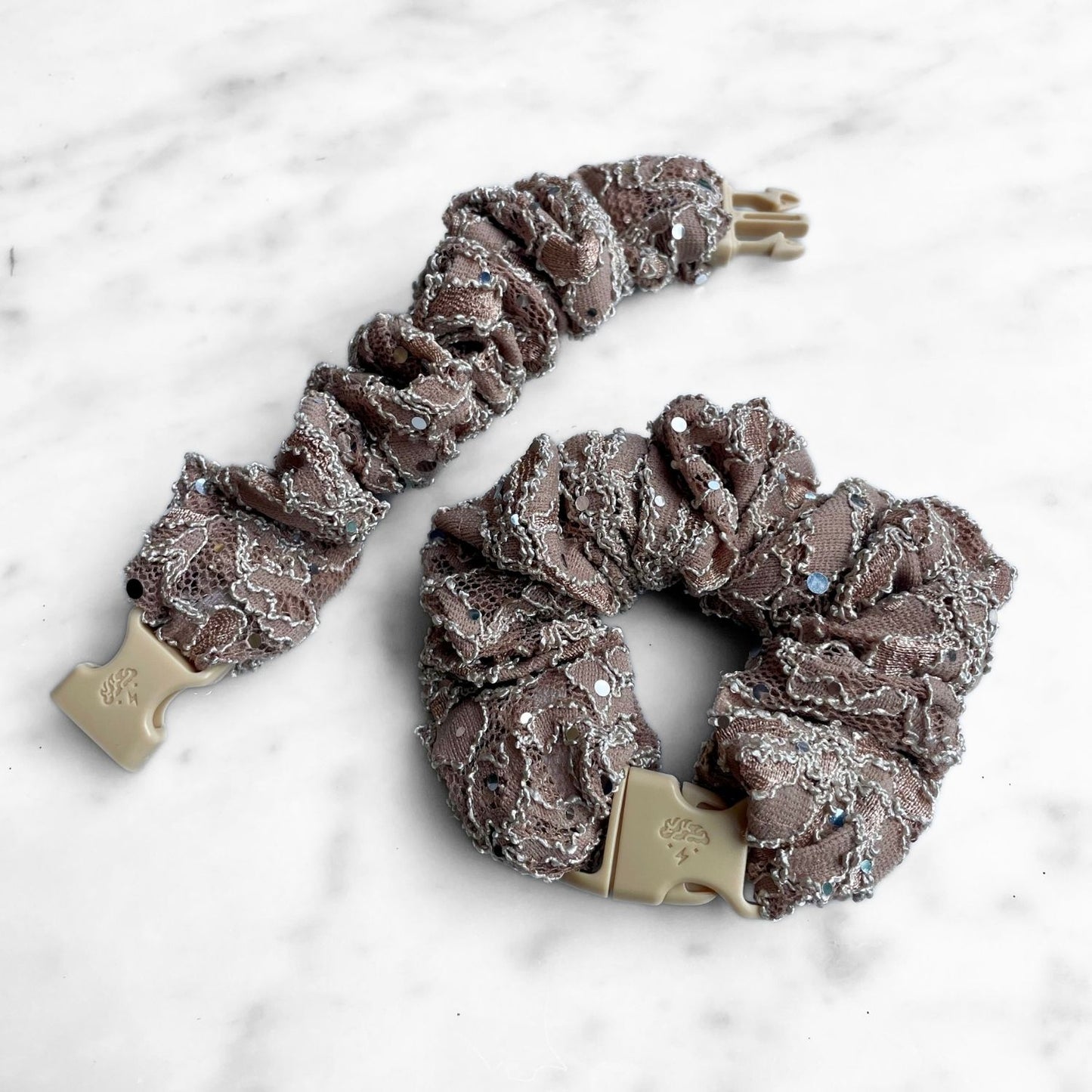 Mauve lace Buckle Scrunchie beside an open one showing the tan buckle prongs