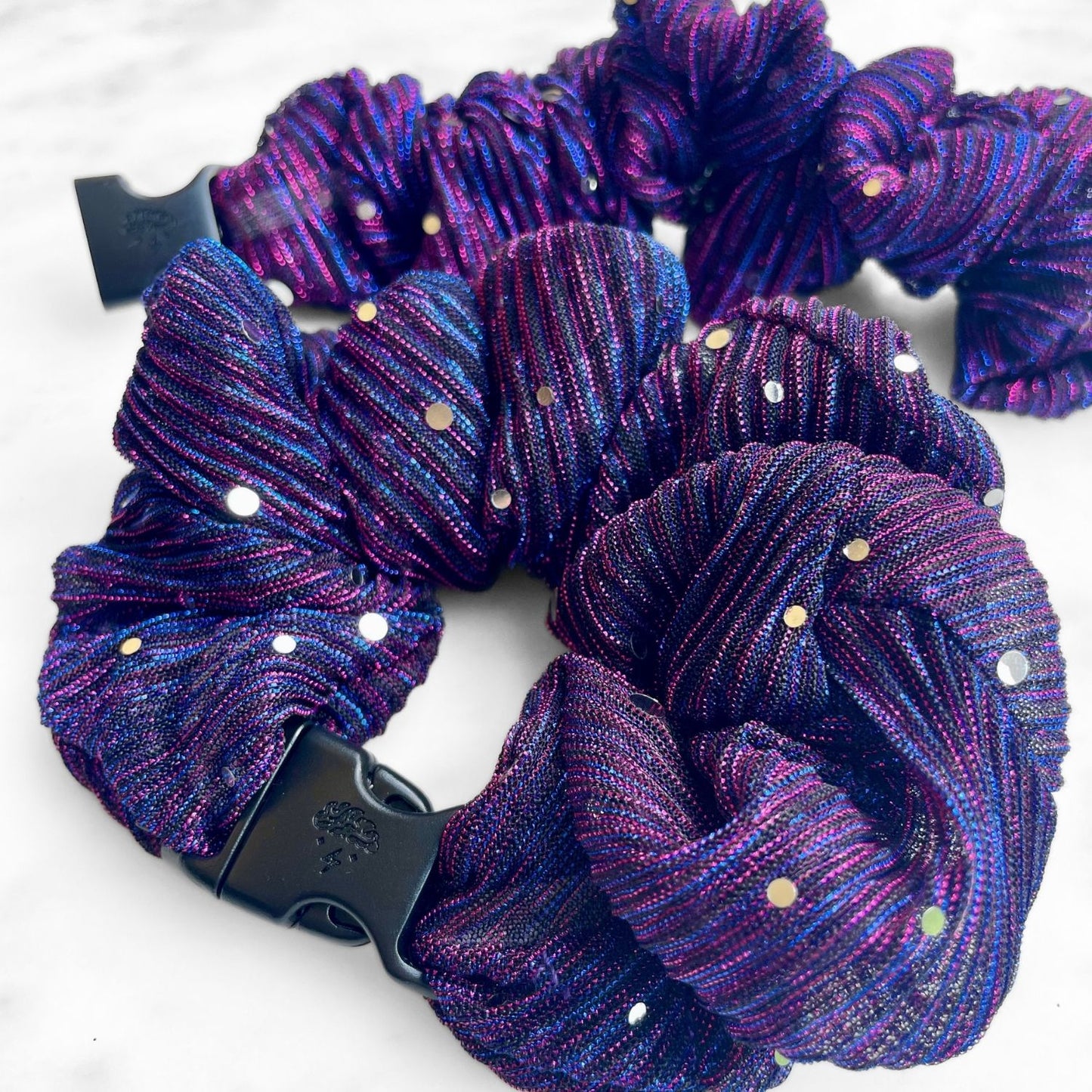 Close view of pleated purple and magenta fabric with iridescent dots