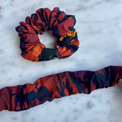 Red and black abstract Buckle Scrunchie beside one opened flat to show its length