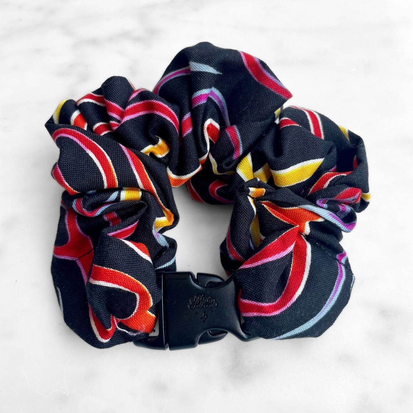 Black ribbon swirl Buckle Scrunchie fastened in a ring with its black buckle