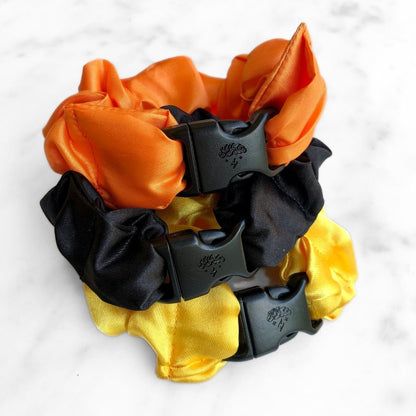 Three Halloween Buckle Scrunchies in orange, black, and purple satin