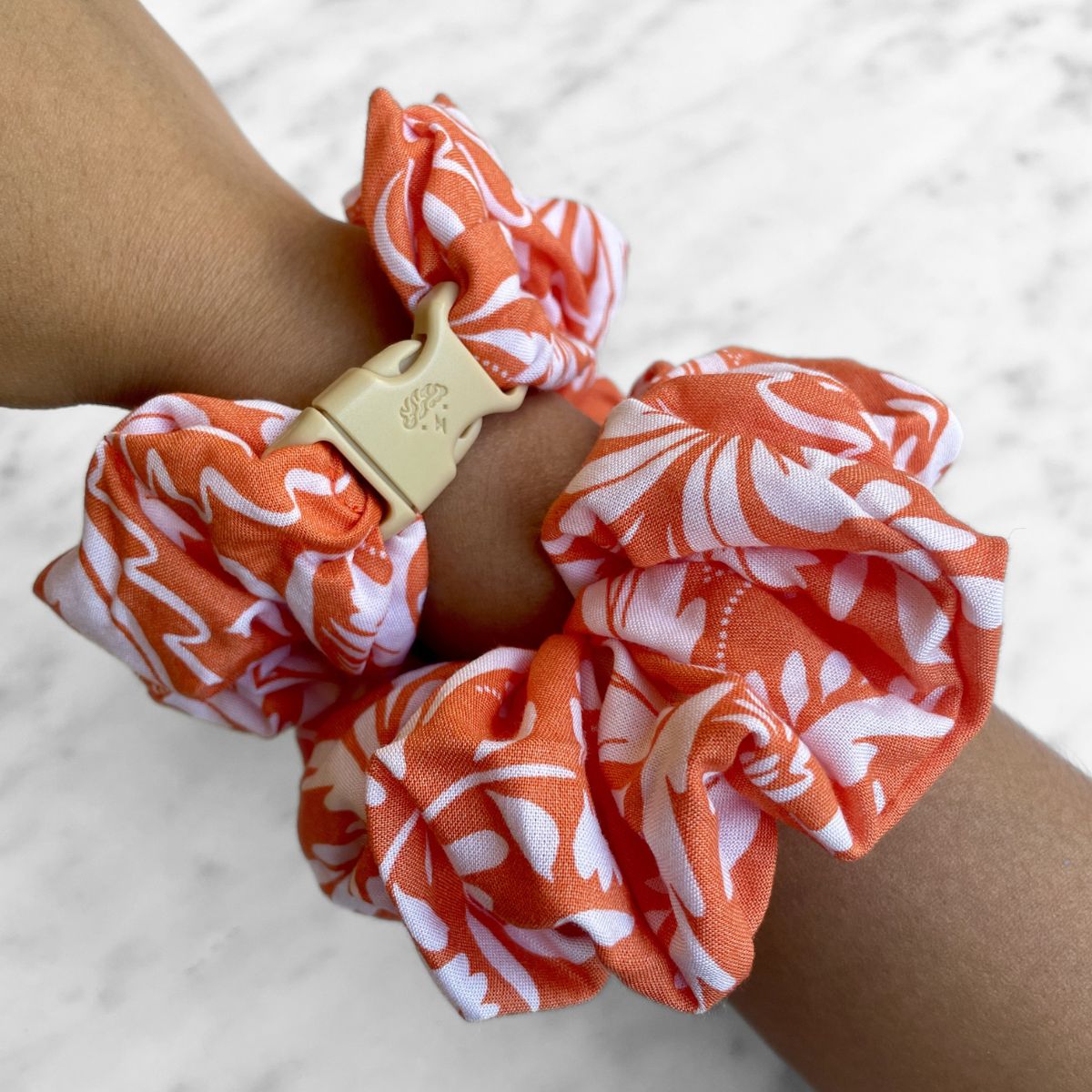Orange floral print detail on the Valencia jumbo Buckle Scrunchie