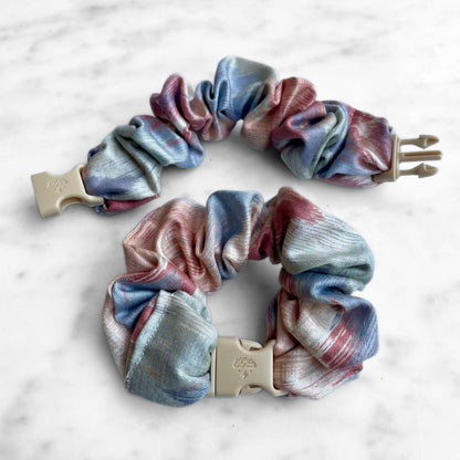 Pink and blue watercolor Buckle Scrunchie beside an open one showing the tan buckle prongs