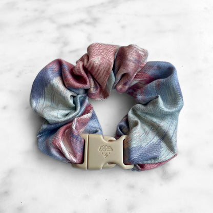 Single pink and blue watercolor Buckle Scrunchie fastened with a tan quick-release buckle