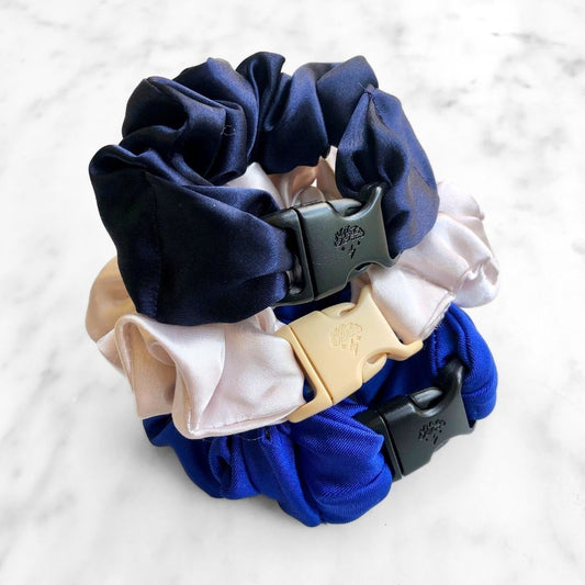 Three Hanukkah Buckle Scrunchies in blue, white, and silver satin